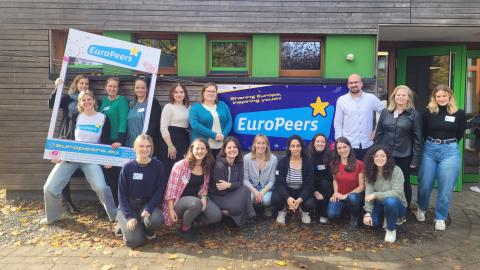 Grupo de personas sujetando un marco y un cartel de EuroPeers