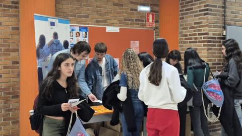 Jóvenes acercándose a una mesa informativa