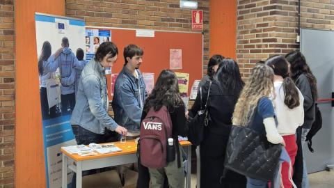 Jóvenes acercándose a una mesa informativa