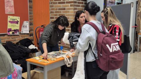 Jóvenes acercándose a una mesa informativa