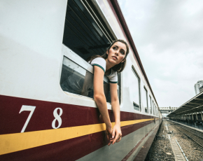 Mujer asomada a la ventanilla de un vagón de tren.